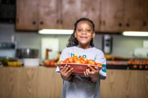 4-Her holding a bowl of tomatoes