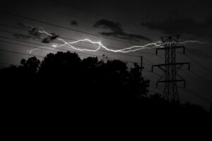 lightning shooting across the sky in a black and white photo 