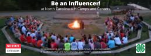 Photo of summer campers sitting around a campfire.