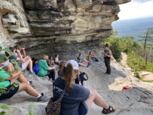 NC Park Ranger teaching 4-H'ers on a rock formation at Pilot Mountain overlooking a valley